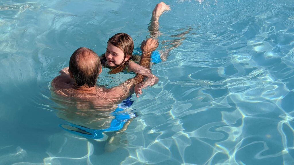 Captain Dave teaches his grand daughter Julia to swim in the pool at River Dunes, NC